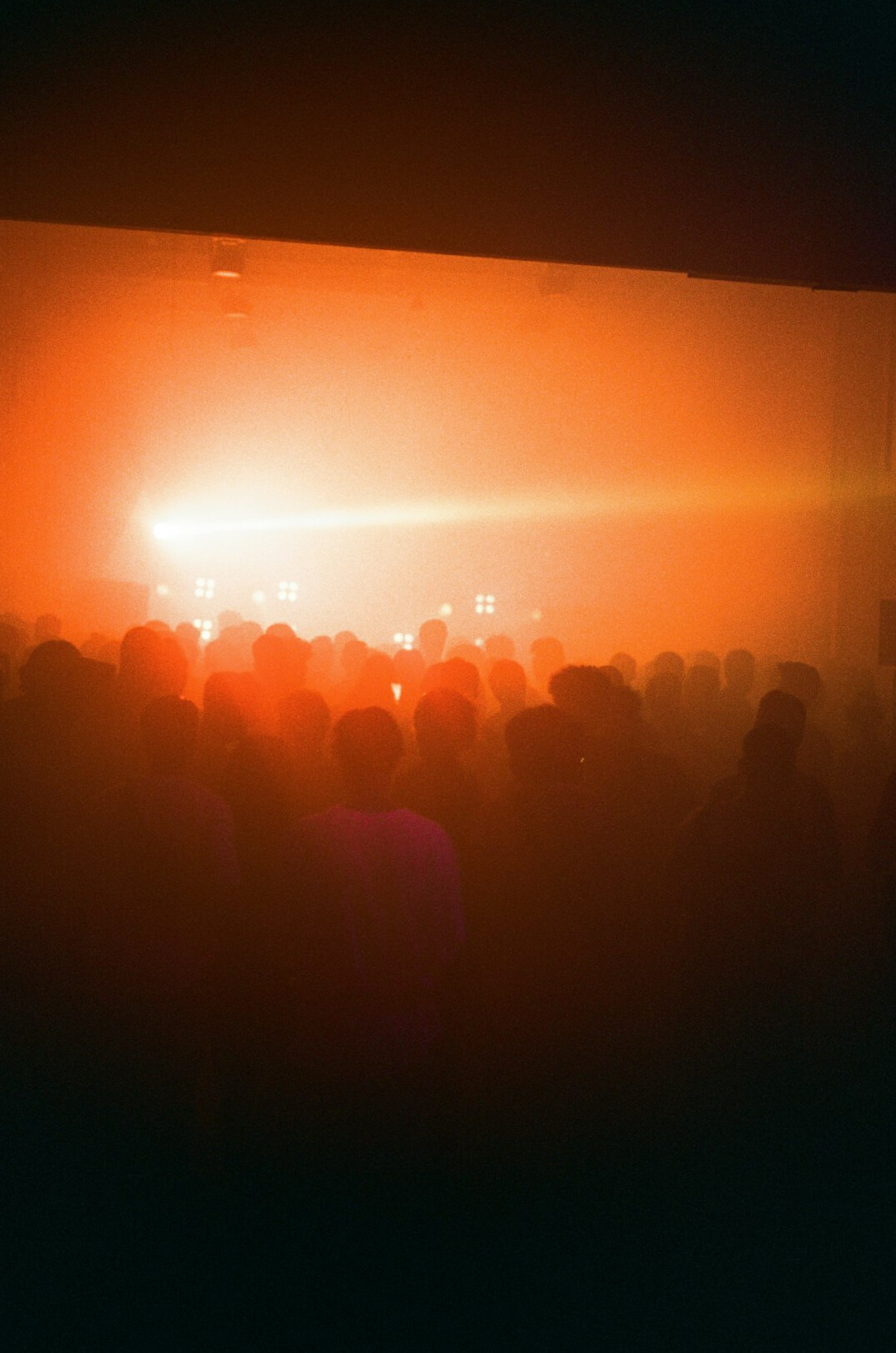 Distant blurred crowd with warm stage lights