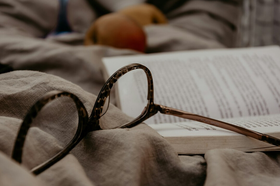 Reading glasses resting on an open book
